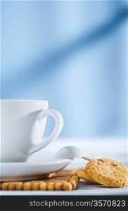 cup with spoon and cookies