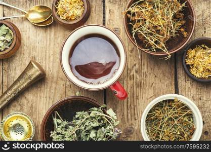 Cup with tea from medicinal herbs on a wooden background. Healing herbal tea
