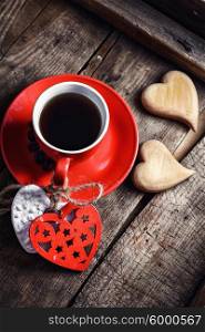 Cup with wooden hearts. Red Cup with black coffee and two carved decorative wooden heart.Top view