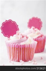 Cupcake muffin with raspberry cream dessert on marble background with pink candies