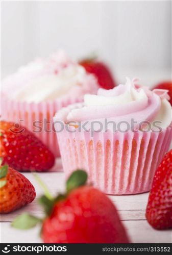 Cupcake muffin with strawberry cream dessert on wooden background with fresh strawberries