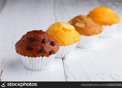Cupcake with chocolate chips, almond and butter on wooden table
