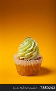cupcake with cream isolated on orange background with copyspace