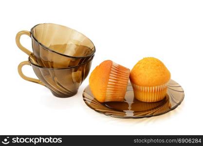Cupcakes and cups for tea isolated against white background