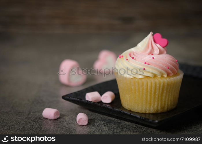 Cupcakes are beautifully decorated in Dark lighting, AF point selection.