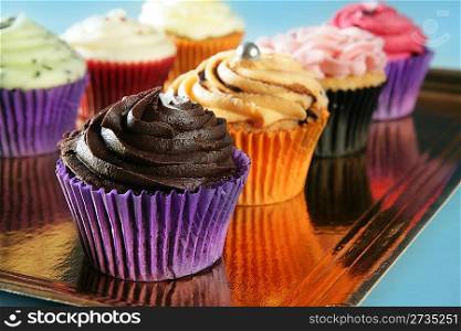 Cupcakes colorful cream muffin arrangement in golden mirror tray