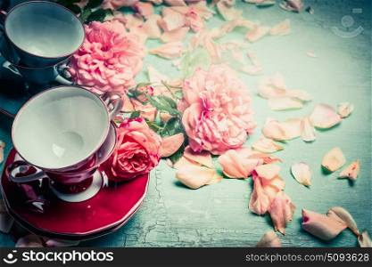 Cups and pink roses on turquoise shabby chic background