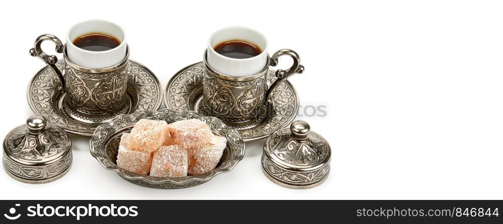 Cups of coffee and turkish delight in a vase isolated on white background. Free space for text. Wide photo.