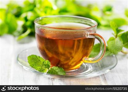 cups of tea with mint on wooden table