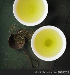 Cups with green tea on wooden background