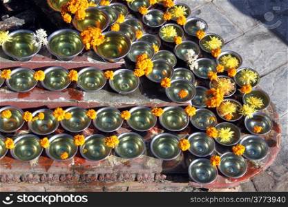 Cups with oil on the corner of shrine near stupa Bodnsth, Nepal