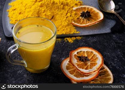 Curcuma  turmeric  spice , curcuma cocktail served with dry oranges at black table. Food and cuisine ingredients. healthy concept. 
