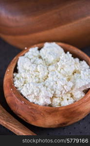 curd in brown wooden bowl closeup. curd in a bowl