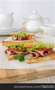 Cured ham sandwich with tomatoes for breakfast with a cup of coffee