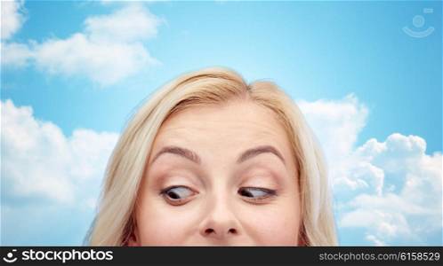 curiosity, advertisement and people concept - happy young woman or teenage girl face over blue sky and clouds background