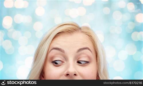 curiosity, advertisement and people concept - happy young woman or teenage girl face over blue holidays lights background