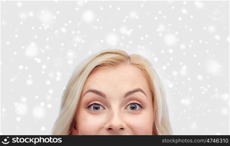 curiosity, winter holidays, christmas and people concept - happy young woman or teenage girl face over snow