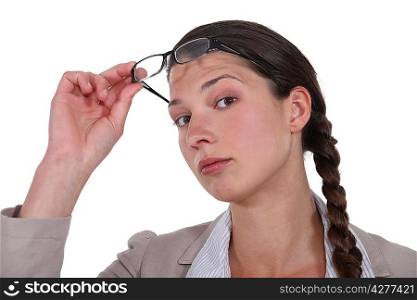 Curious brunette lifting her eyeglasses