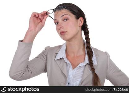 Curious businesswoman lifting glasses