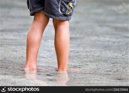 Curious child exploring and wading in shallow ocean water