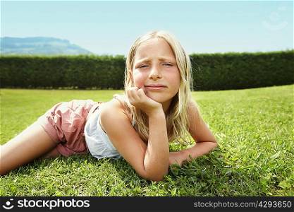 Curious girl laying in grass