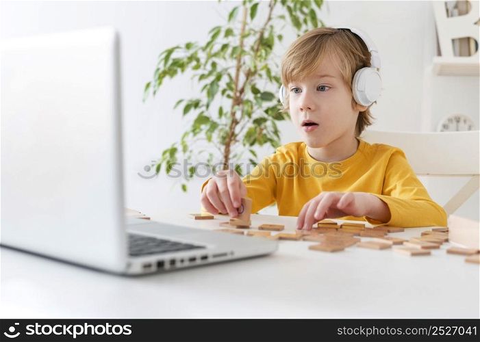 curious little boy using laptop headphones home