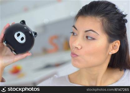 Curious woman holding a piggy bank
