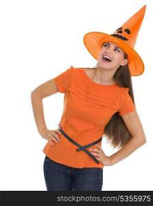 Curious young woman in Halloween hat looking on copy space