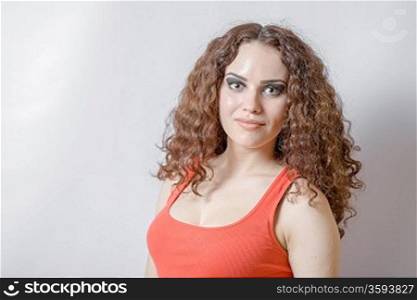 curly hair brunette on white background weared orange red shirt positive girl joy happyness concept