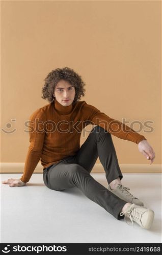 curly haired man with brown blouse posing 13