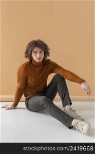 curly haired man with brown blouse posing 13