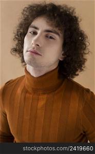 curly haired man with brown blouse posing 4