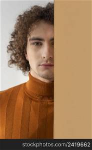 curly haired man with brown blouse posing 7