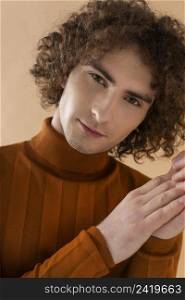 curly haired man with brown blouse posing 8
