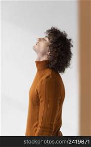 curly man with brown blouse posing 4