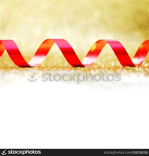 Curly red gift ribbon on glitters background close-up