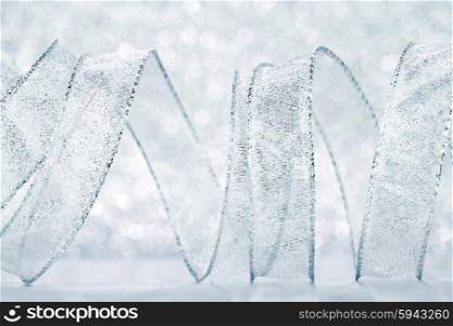 Curly silver serpentine on shiny glitter background, holiday concept