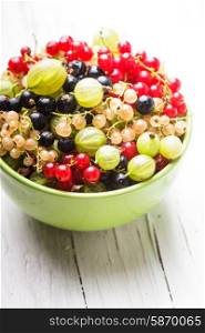 Currants and gooseberry in a bowl on the table. Currants and gooseberry