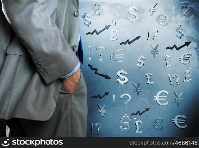 Currency concept. Bottom view of businessman and currency signs at background