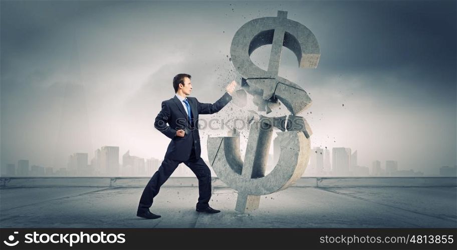 Currency concept. Businessman breaking stone dollar symbol with karate punch