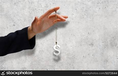 Currency concept. Close up of businessman hand and dollar sign hanging on finger