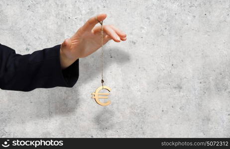 Currency concept. Close up of businessman hand and euro sign hanging on finger