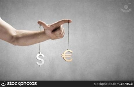 Currency concept. Close up of human hand and items hanging on fingers