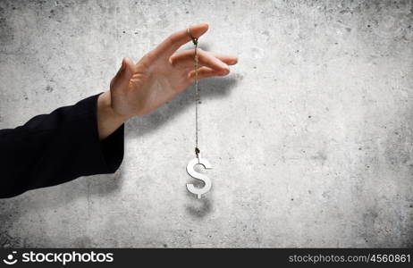 Currency concept. Close up of male hand holding dollar sign on rope