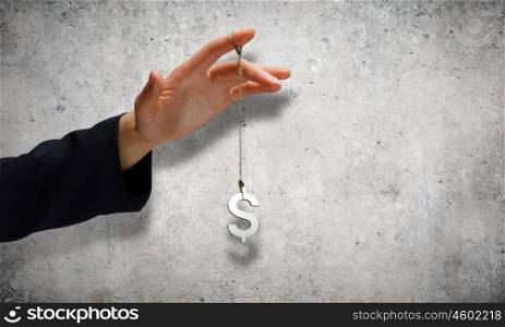 Currency concept. Close up of male hand holding dollar sign on rope