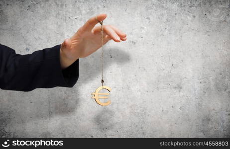 Currency concept. Close up of male hand holding euro sign on rope