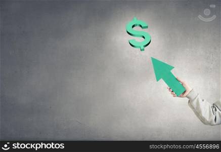 Currency concept. Hand of businessman holding arrow and pointing at dollar sign
