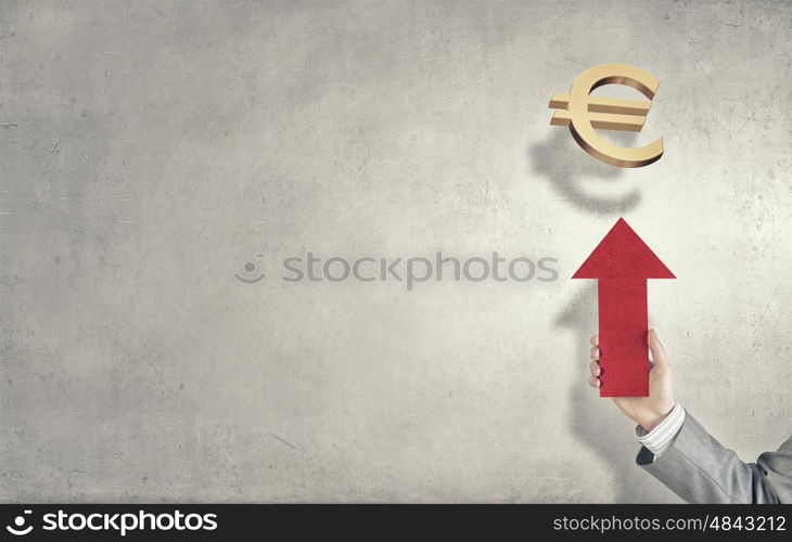 Currency concept. Hand of businessman holding arrow and pointing at euro sign