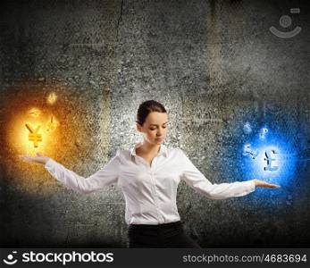 Currency concept. Image of young businesswoman holding symbols in palms