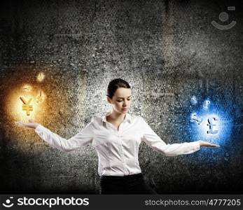 Currency concept. Image of young businesswoman holding symbols in palms